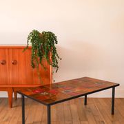 Ceramic and black iron coffee table, attributed to the Roche-Bobois brand, with a black metal base and structure, rectangular ceramic top from Vallauris with colourful patterns in ochre and orange, design from the 1970s.