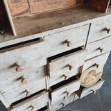 Craft cabinet with drawers with a very old tobacco advertisement in the background