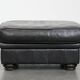 Set of a black cowhide leather Chesterfield armchair and matching ottoman