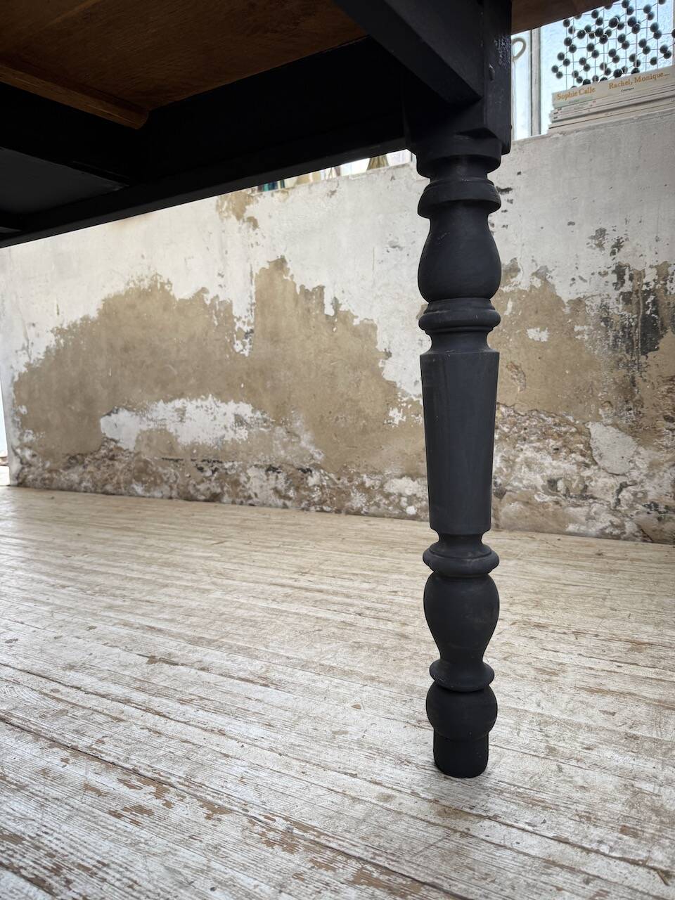 Oak farmhouse table with turned black legs.