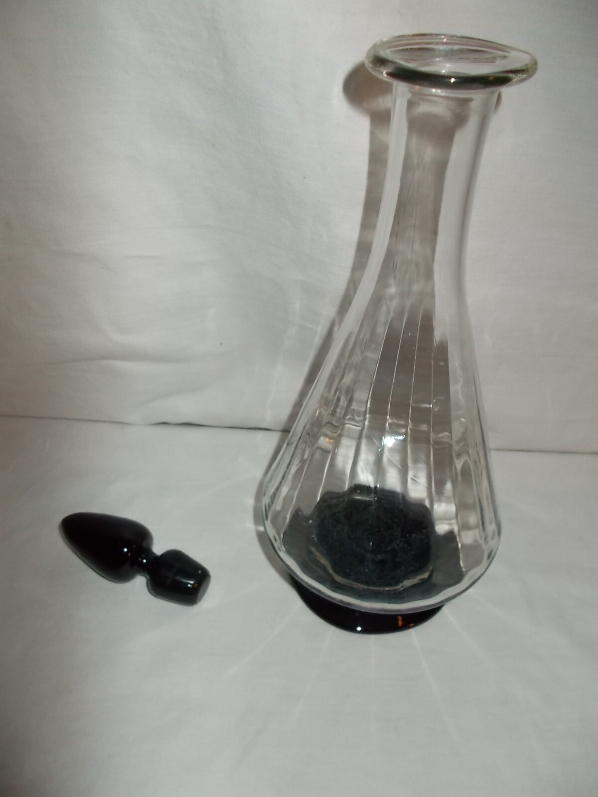 Dark purple glass wine carafe with a stopper.