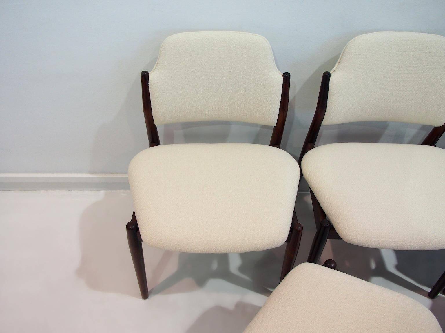 Set of six hardwood chairs by Arne Vodder for Sibast with white textile upholstery.