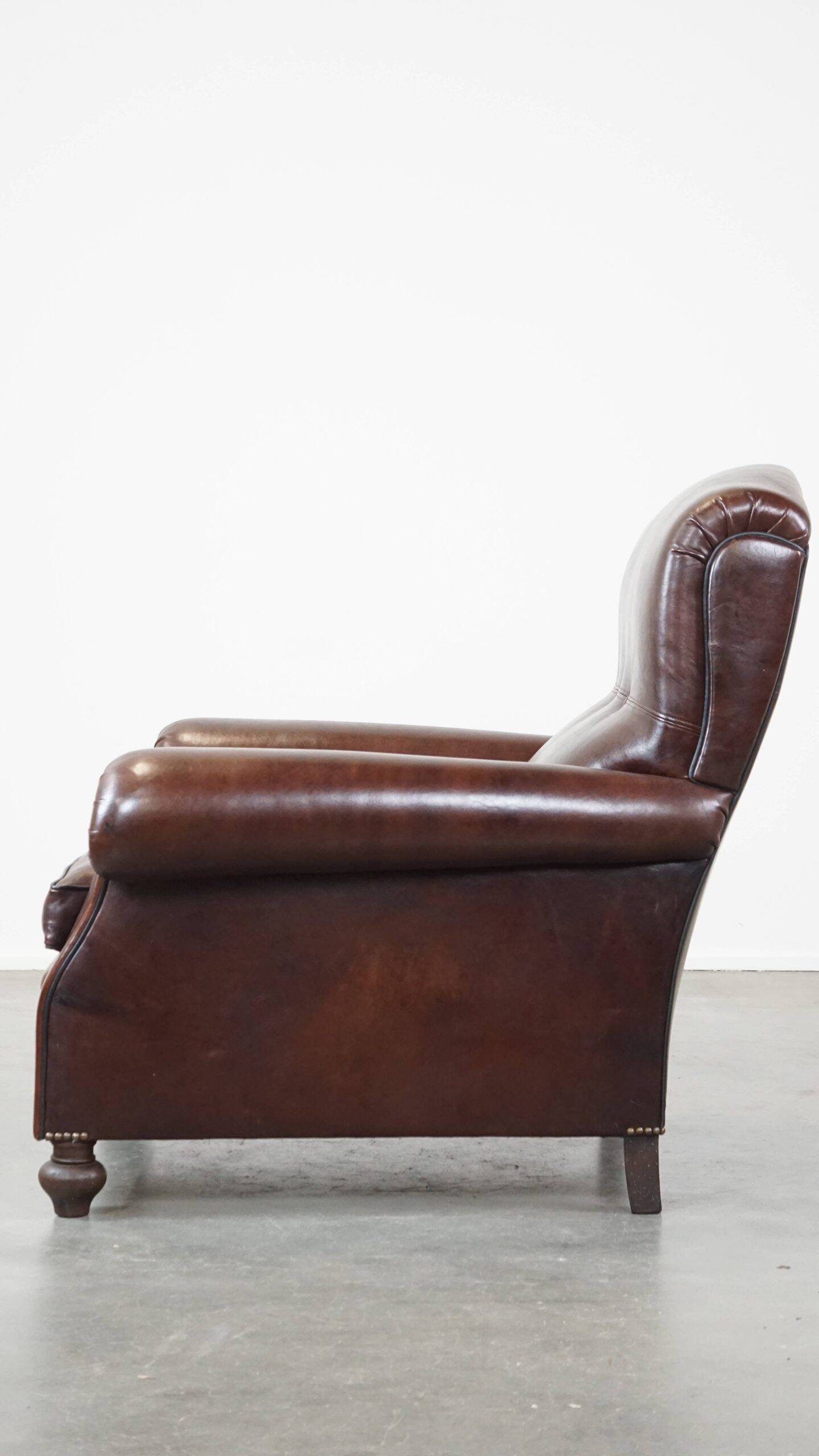 Comfortable and correct dark antique sheepskin English armchair in very good condition