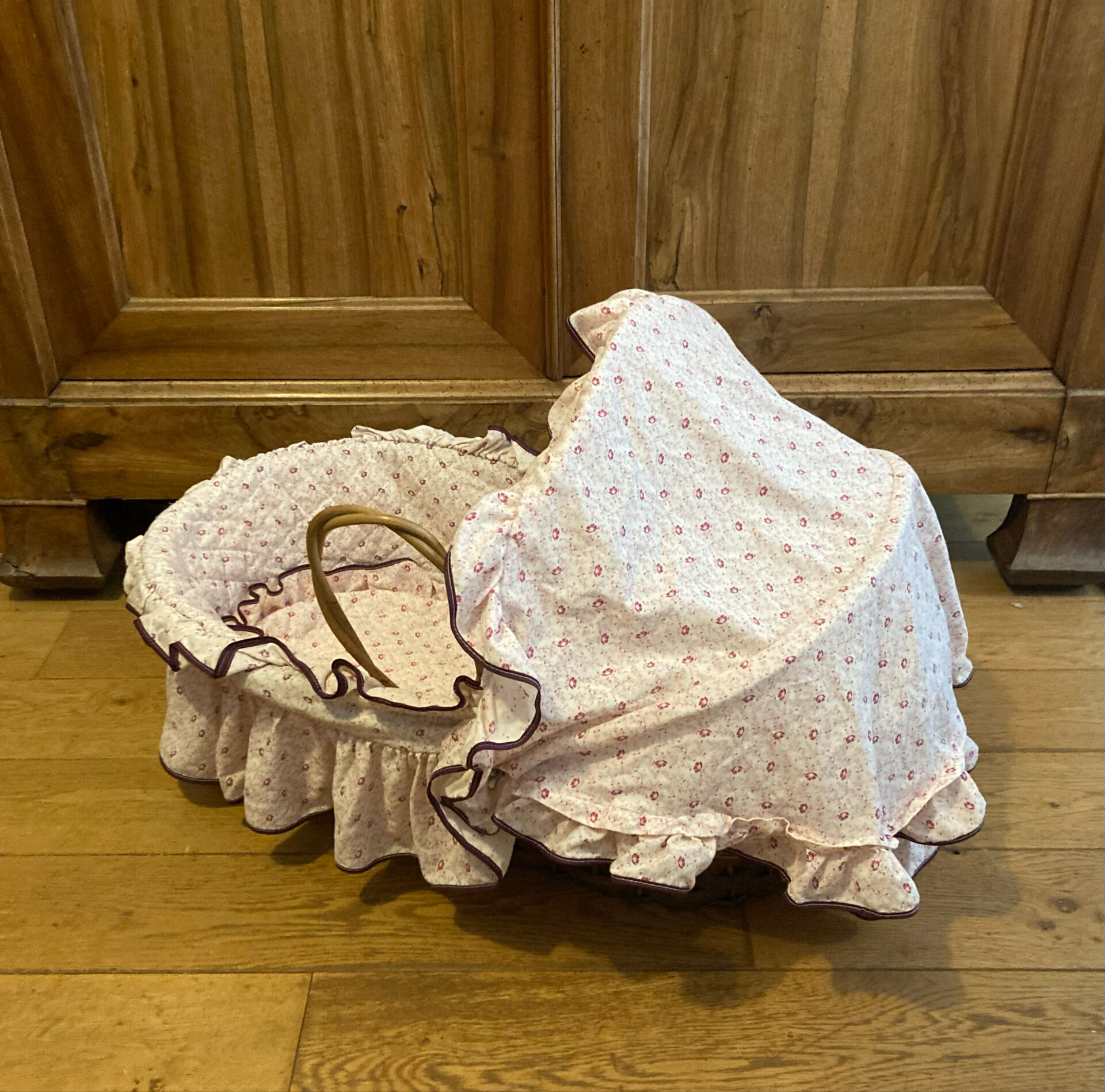 1960s wicker cradle with mattress and drapes.