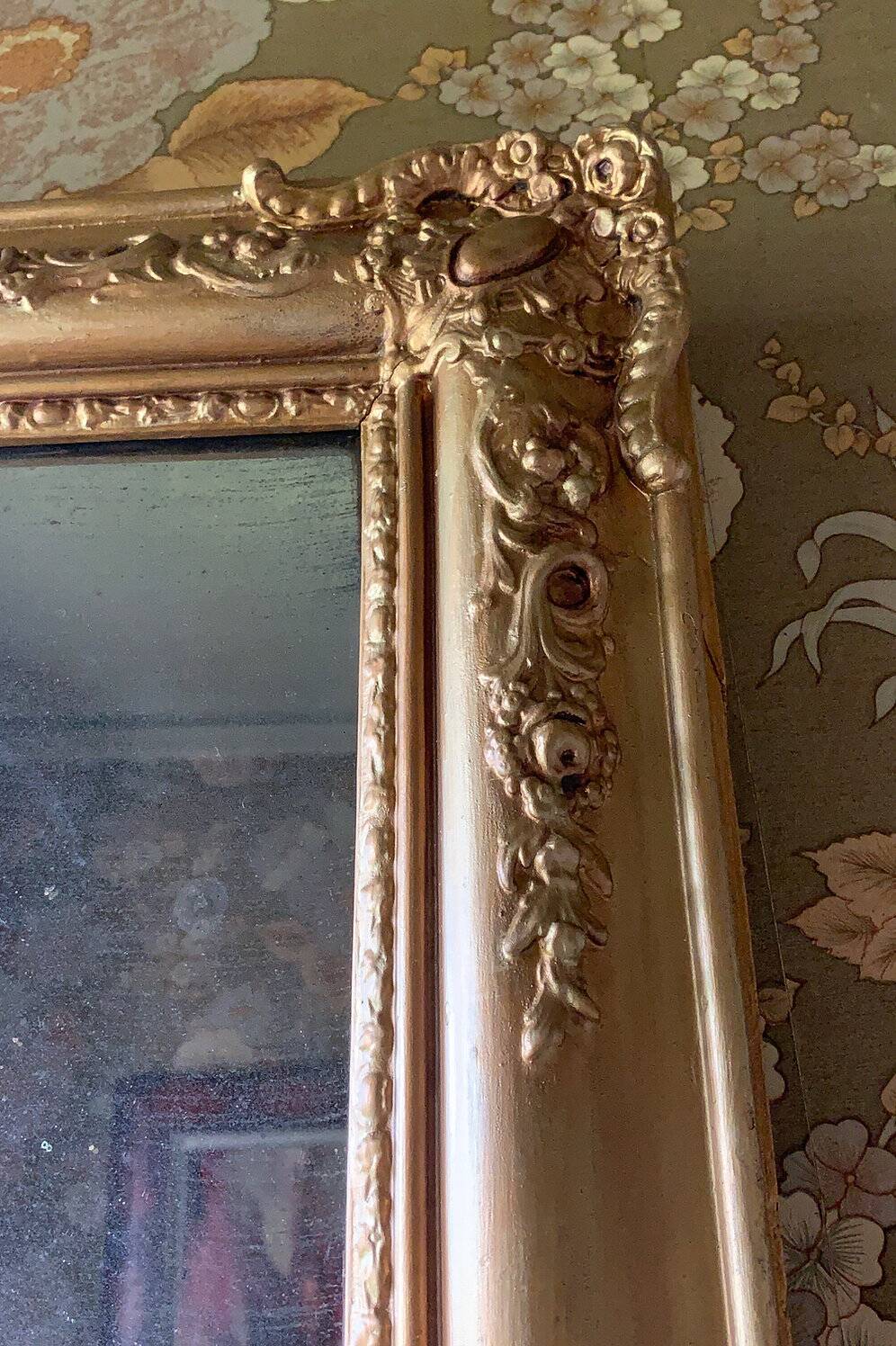 Miroir ancien en bois sculpté doré à décor de fleurs