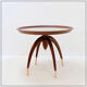 Round Art Deco side table in wood with curved legs and brass feet.