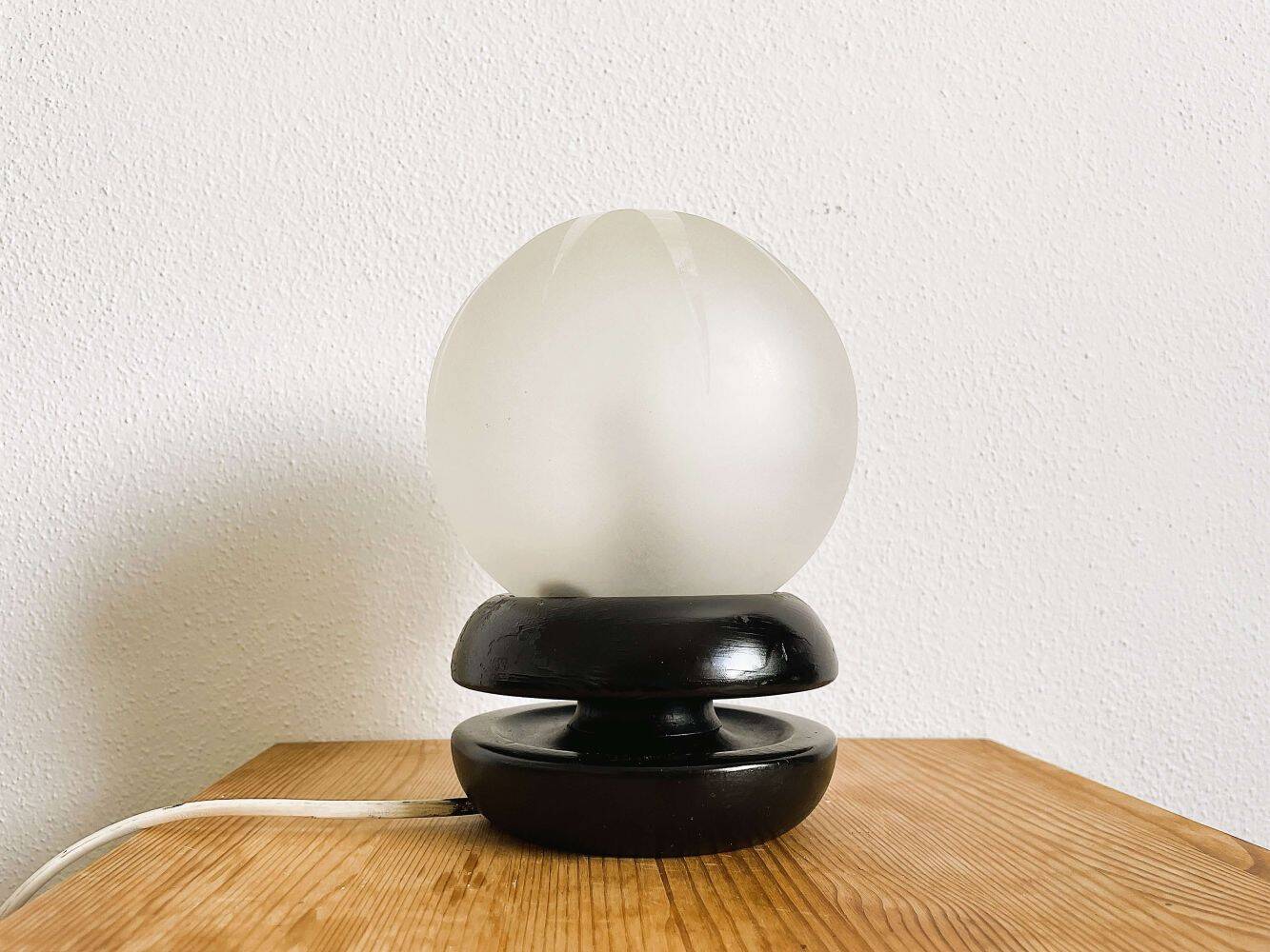 Small black wooden table lamp with frosted glass globe