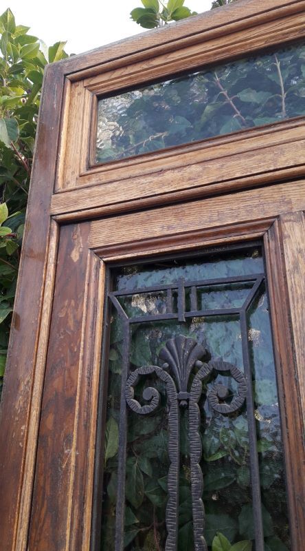Oak entrance door and its frame and transom, wrought iron gates