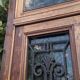Oak entrance door and its frame and transom, wrought iron gates