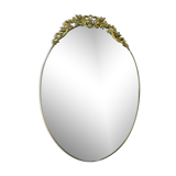 Miroir mural ovale antique dans un cadre en laiton avec ornement supérieur