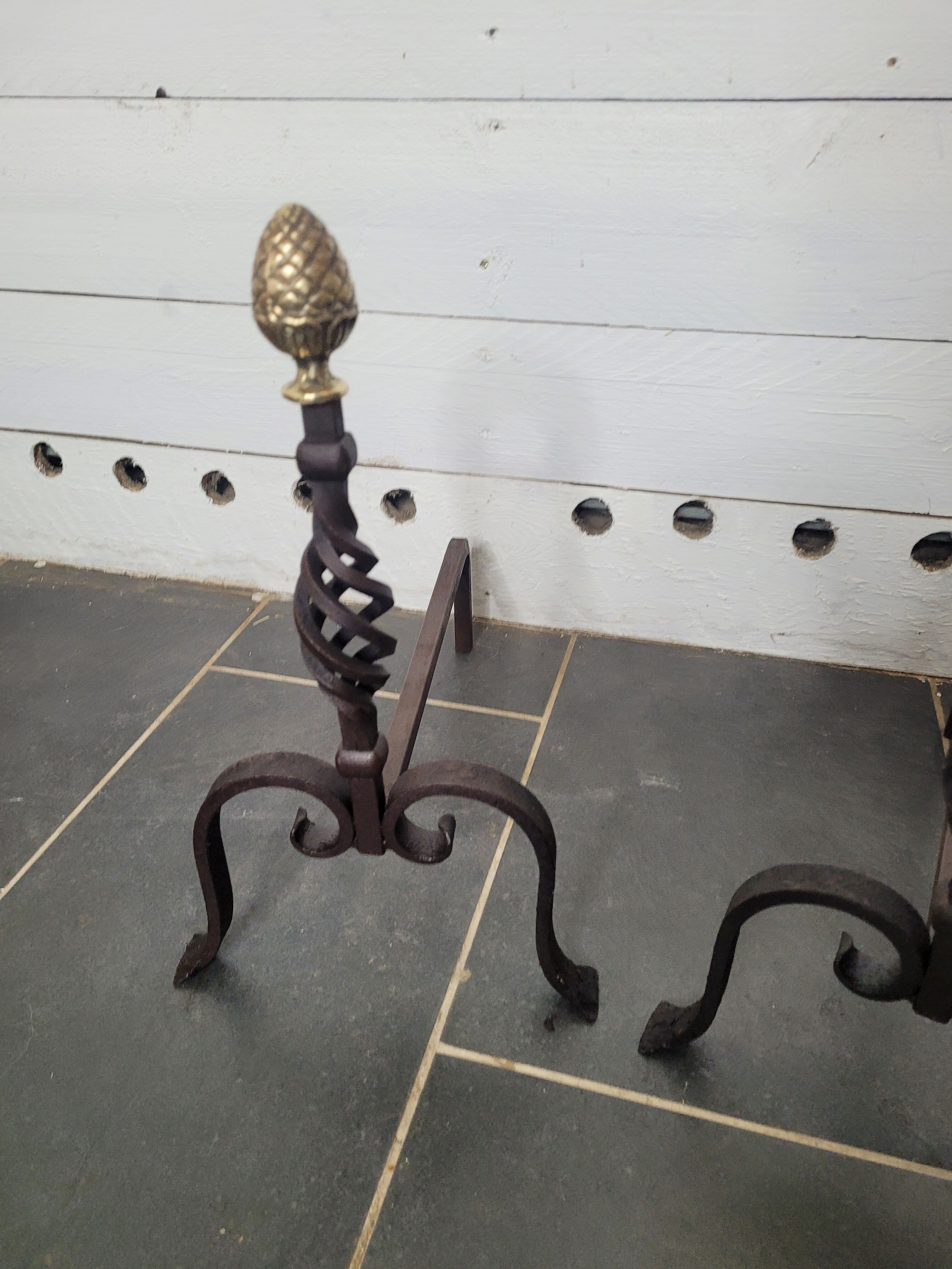 Old pair of wrought iron pegs with brass pine cone