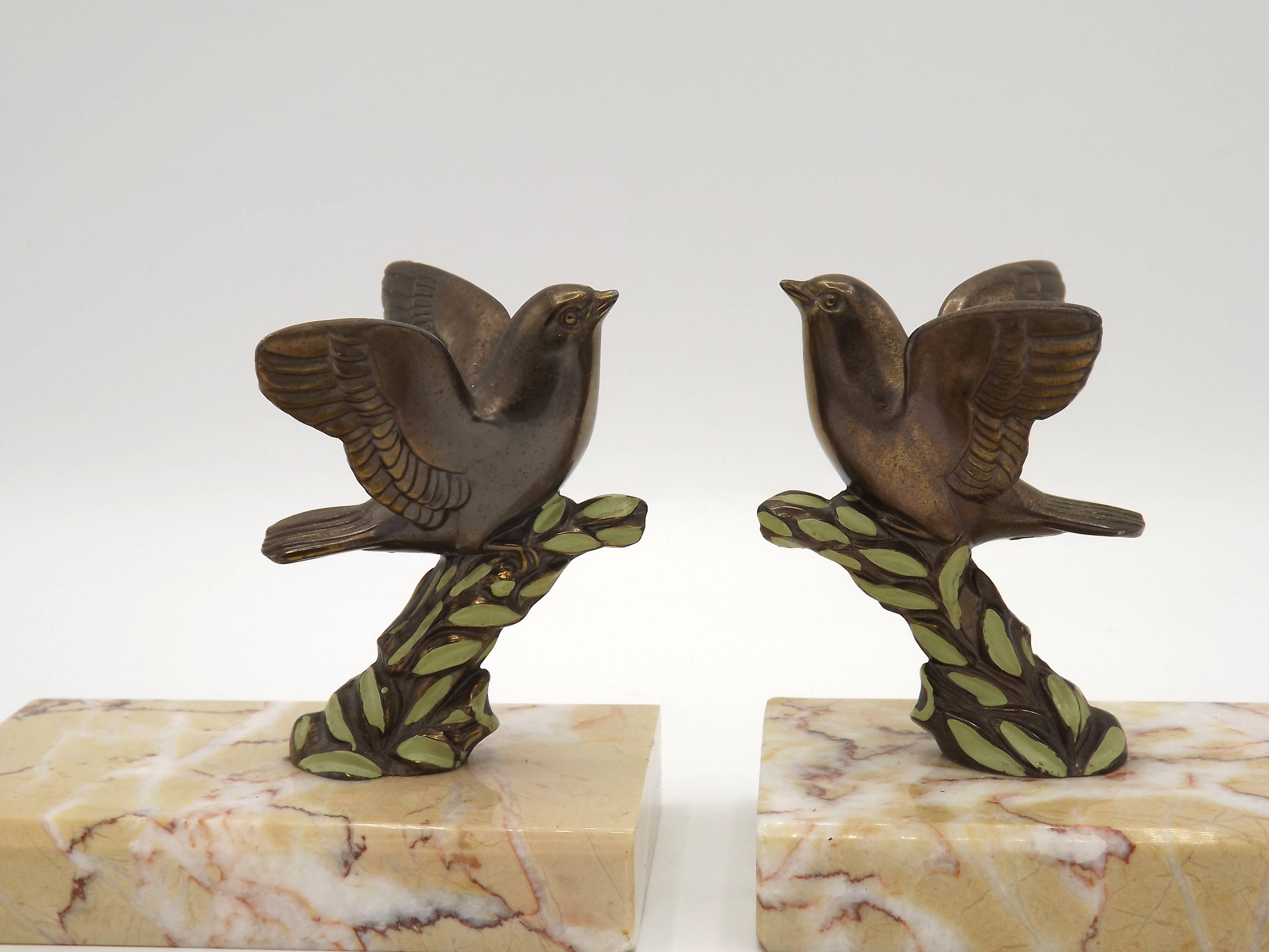 Paire de serre-livres Art déco français en étain représentant des oiseaux perchés sur une branche, socle en marbre