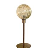 Table lamp with a gold striped globe and a gold foot