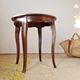 Vintage solid wood side table with curved legs.