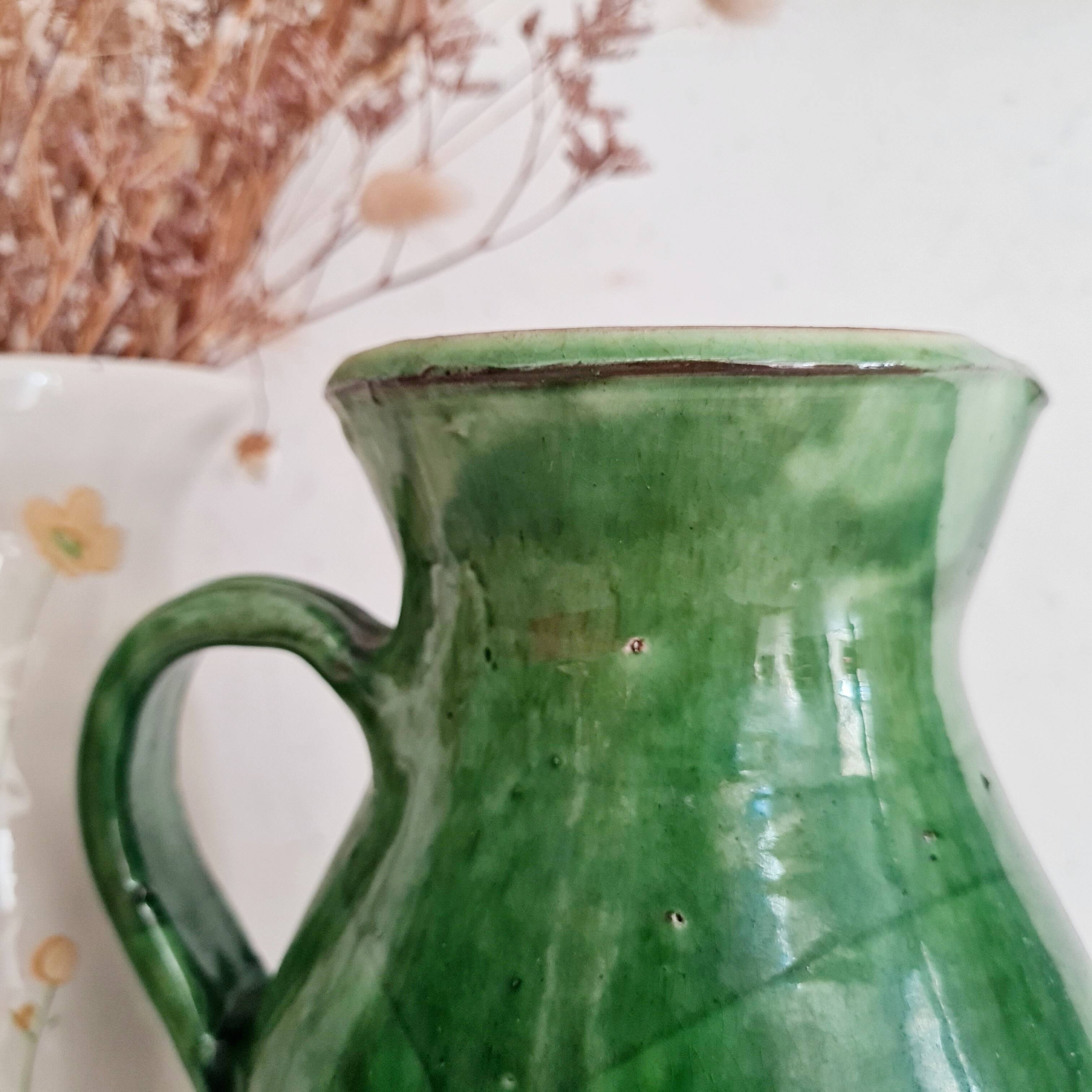 Antique green pitcher in painted terracotta