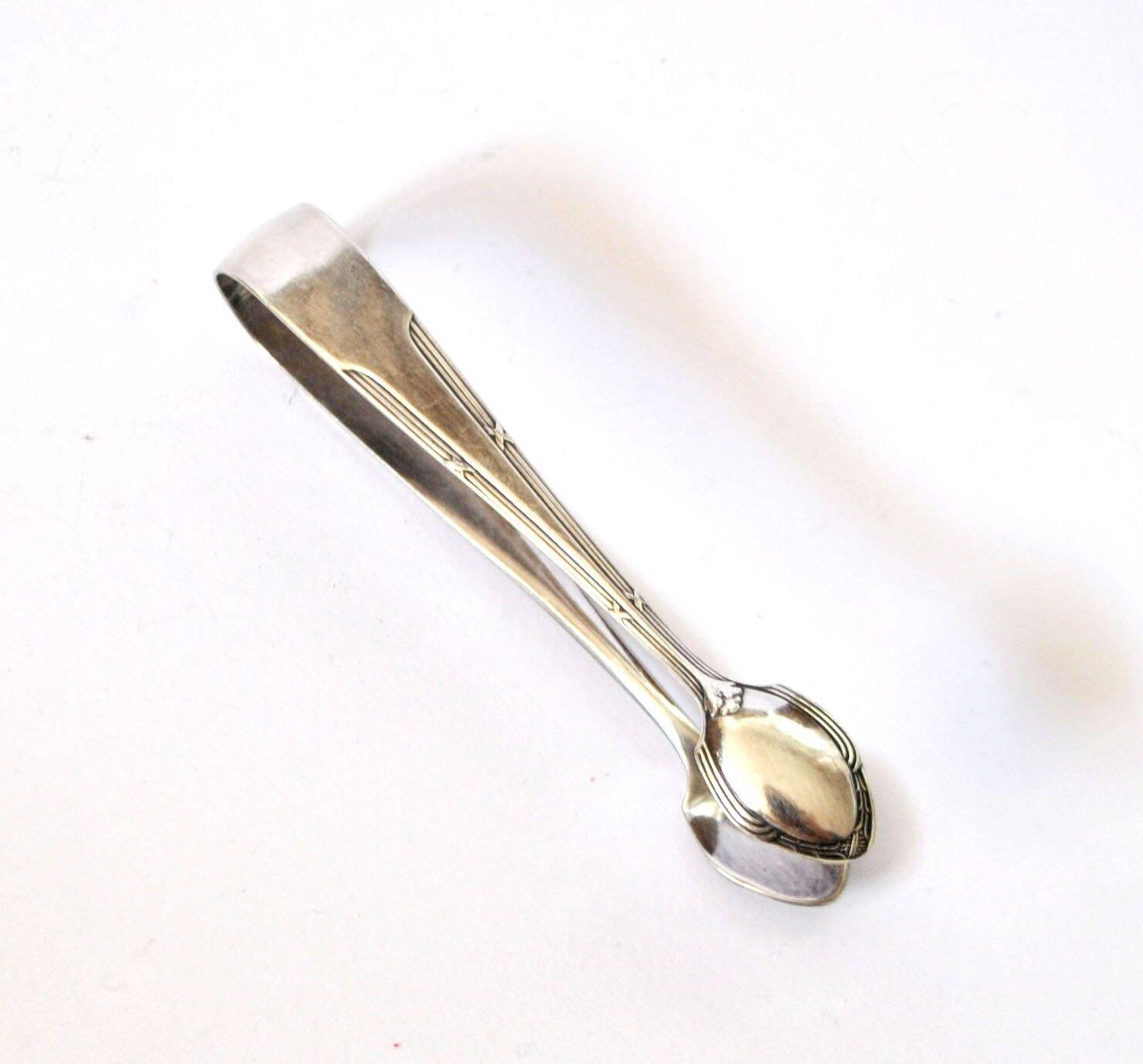 WMF vintage sugar tongs in silver-plated metal with crossed ribbon decoration.