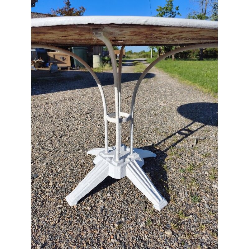 Garden table with a cast iron base and a metal top.