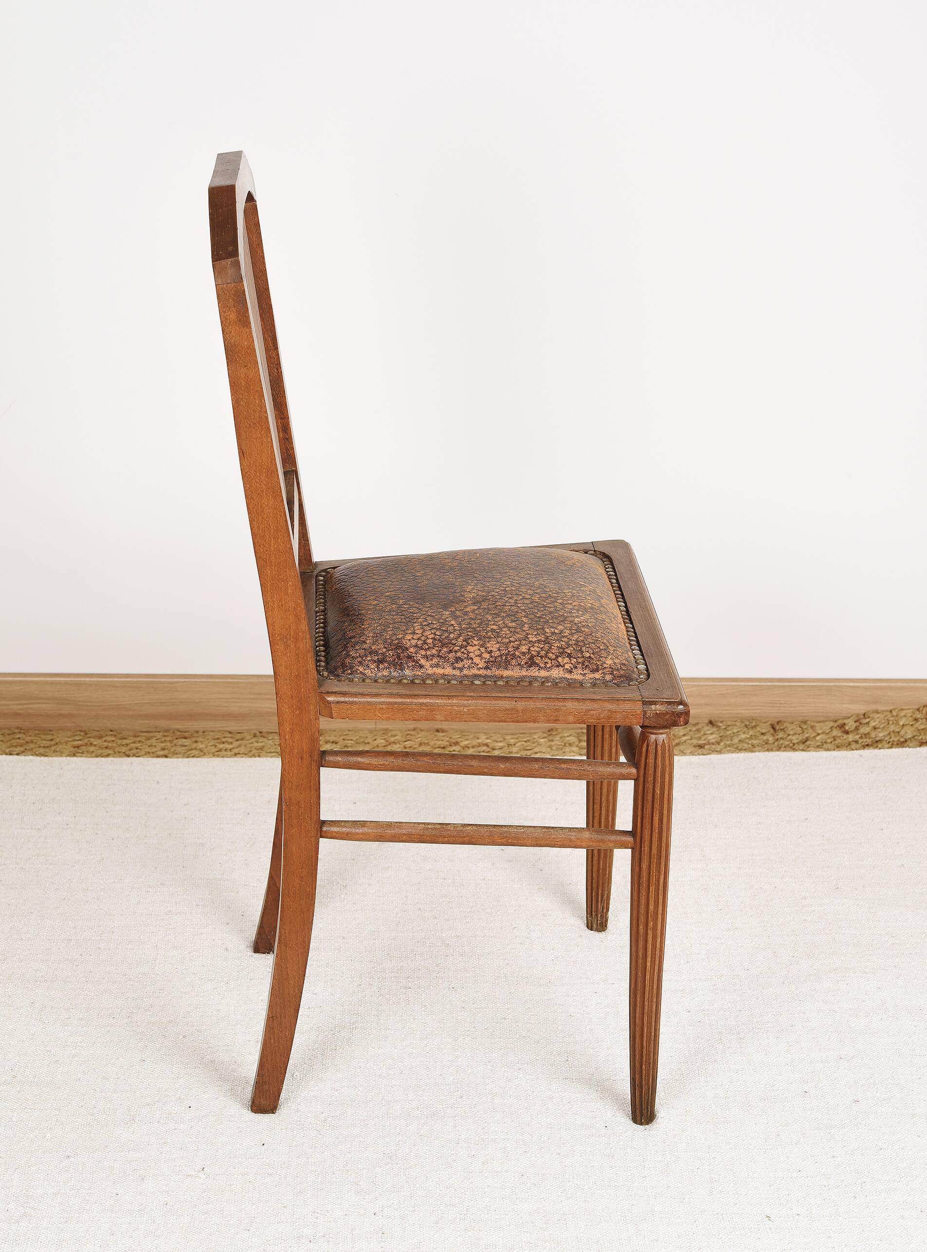 Art Deco style chair in carved wood and leather.