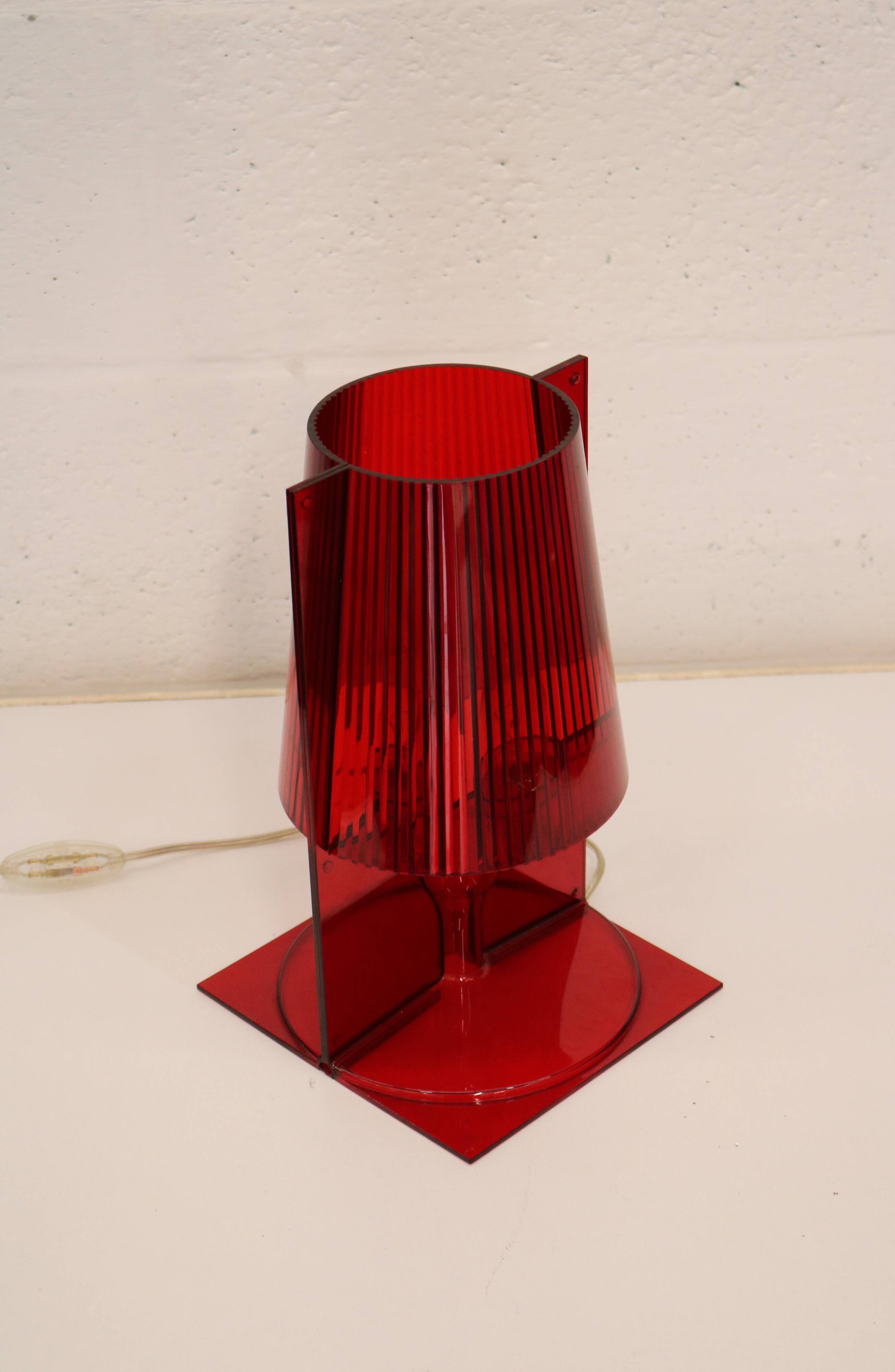 Red plastic Kartell table lamp - model Take - design by Ferruccio Laviani