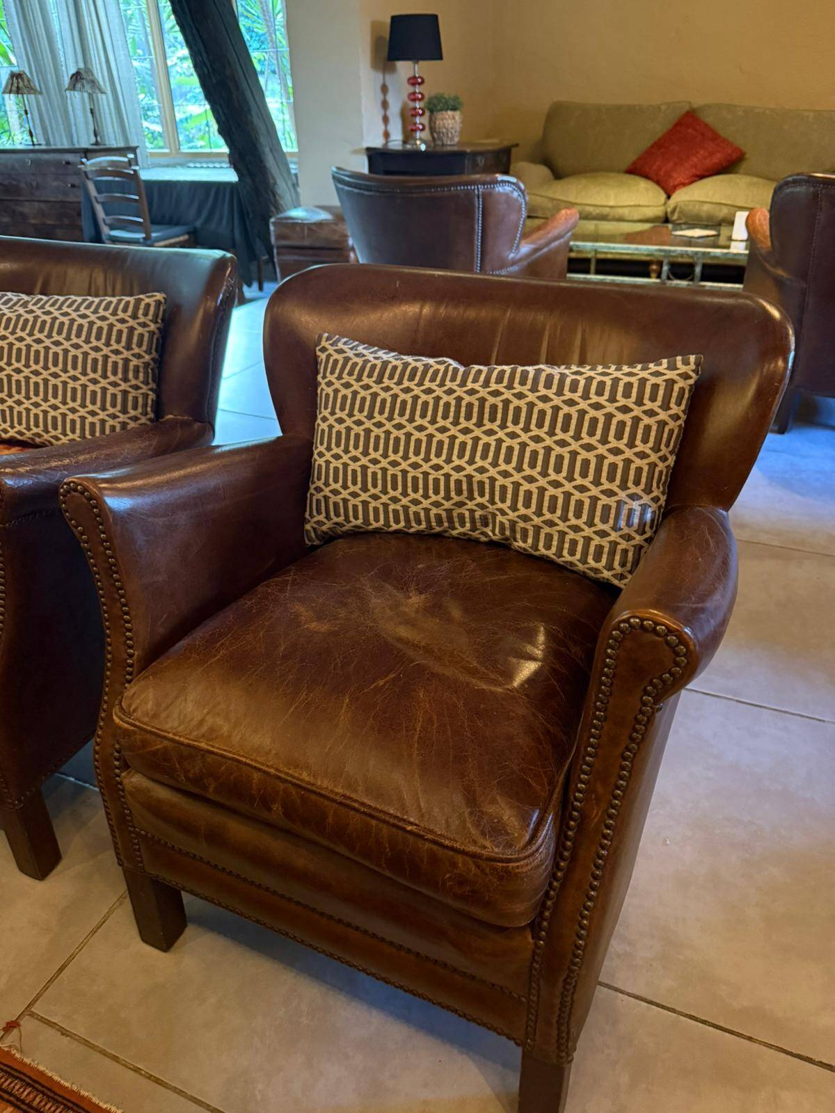 Brown cowhide armchair with a reversible seat cushion in KELIM.