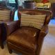 Brown cowhide armchair with a reversible seat cushion in KELIM.