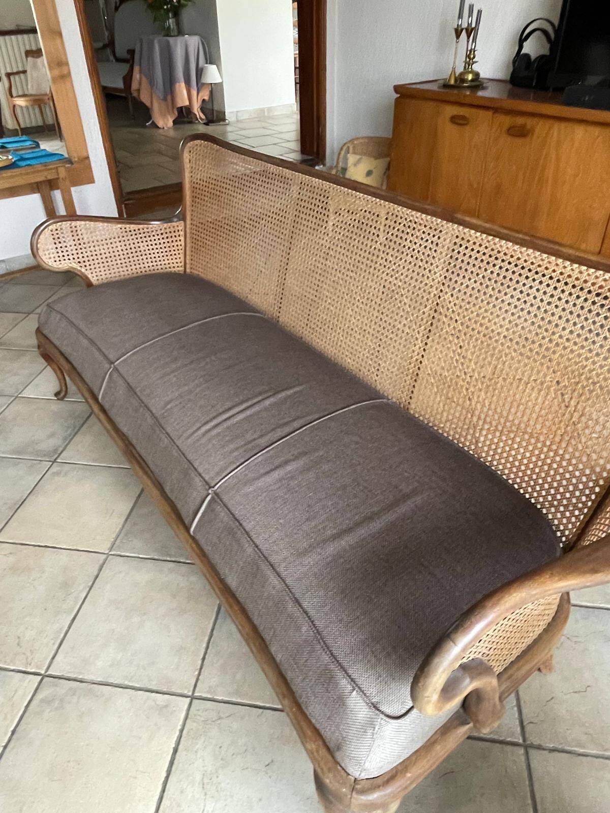 Sofa with backrest and cane armrests