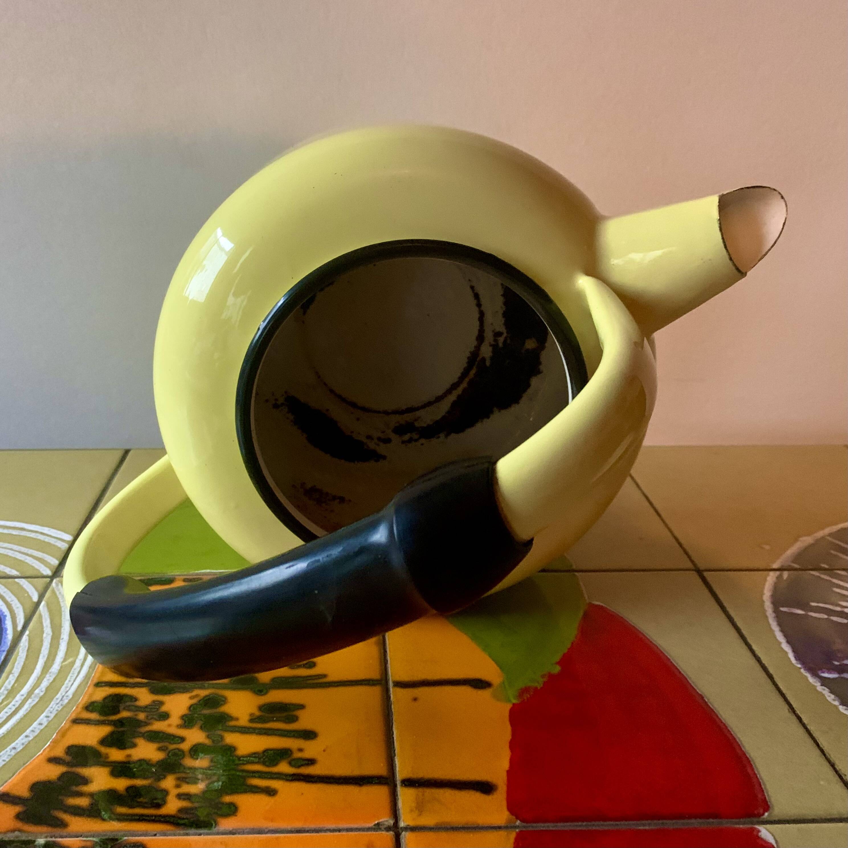 Old kettle in yellow enamelled sheet metal and Bakelite