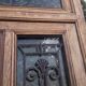 Oak entrance door and its frame and transom, wrought iron gates