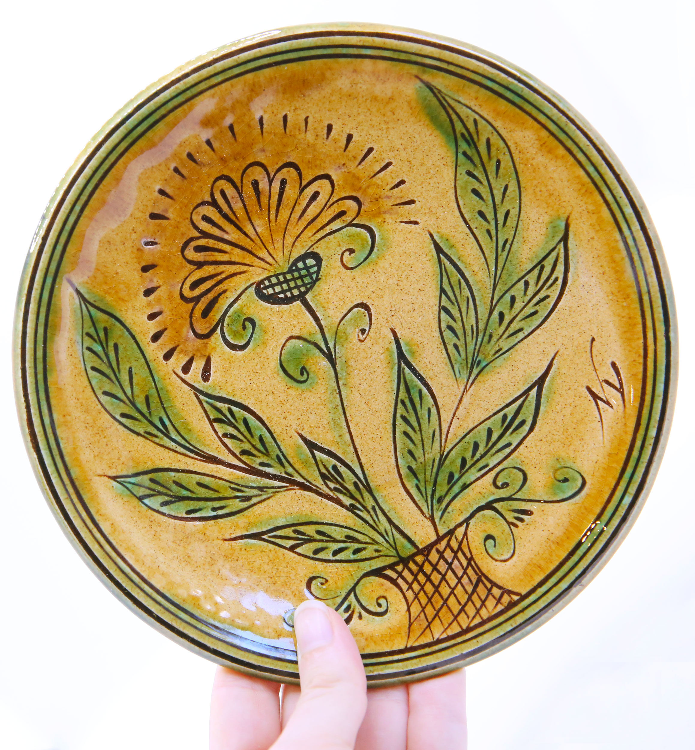 Bulgarian artisanal plate with autumn-hued flower