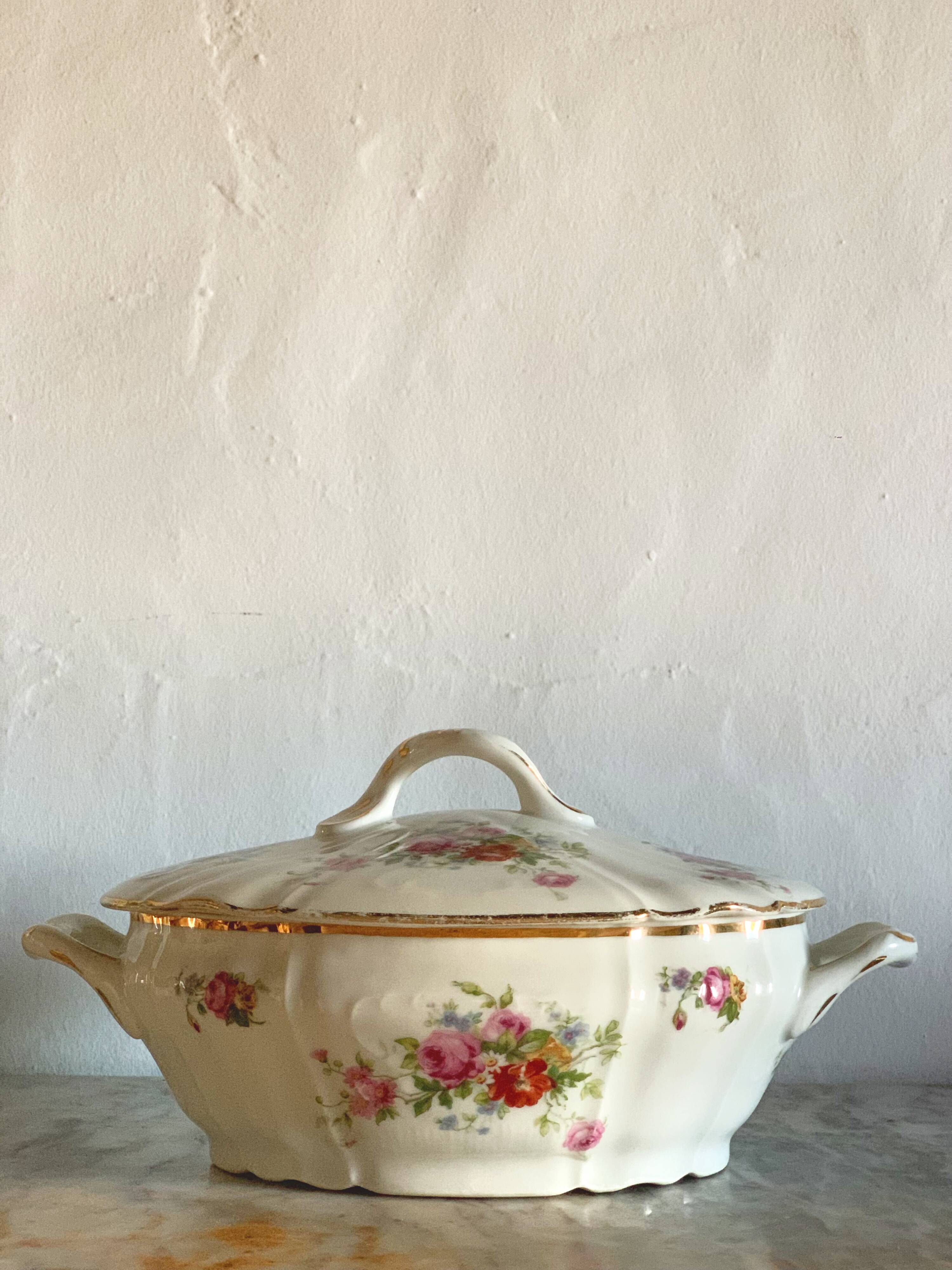 Antique porcelain soup bowl with floral decoration and golden border