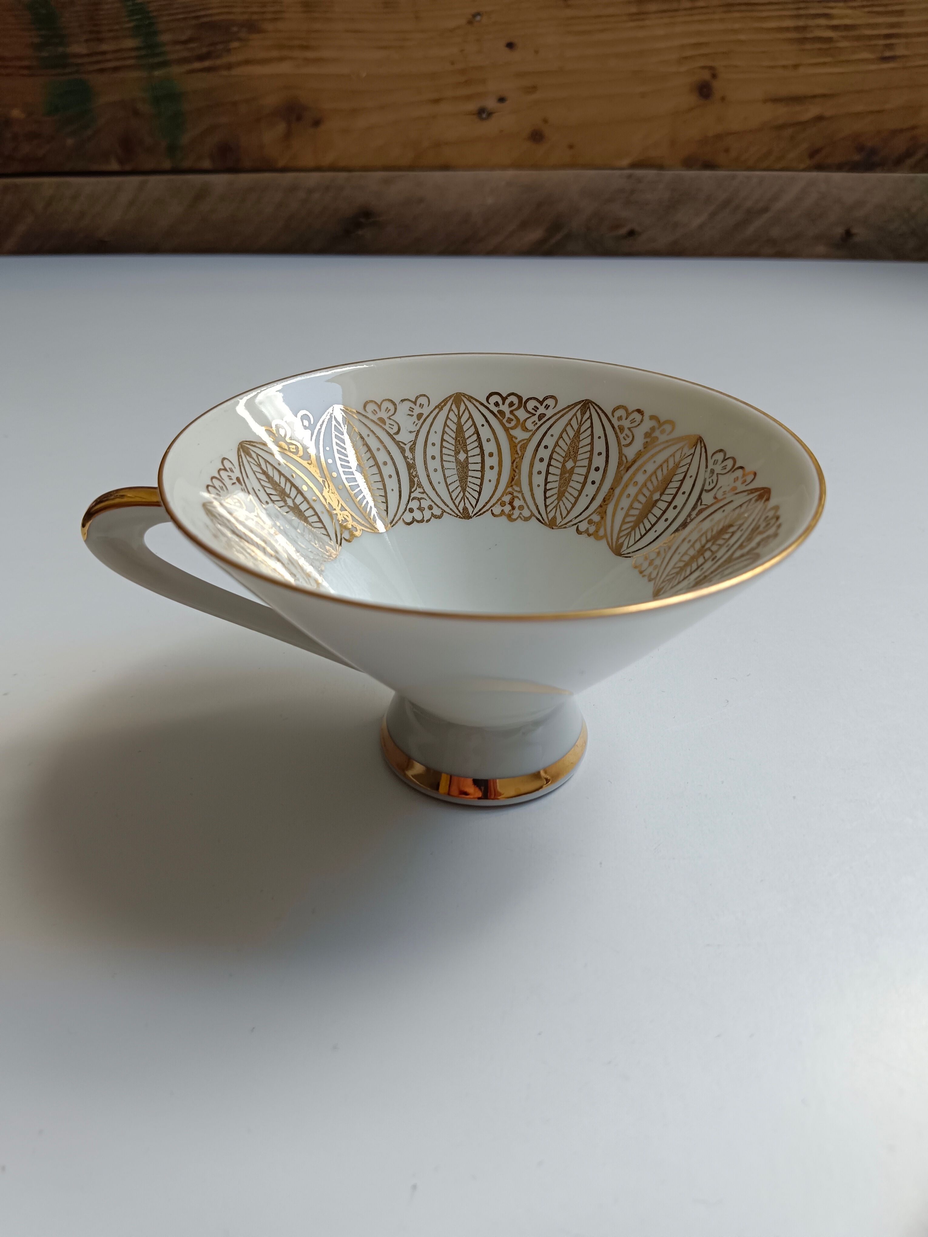 Solitaire tea cup, saucer, and dessert plate in white and gold.