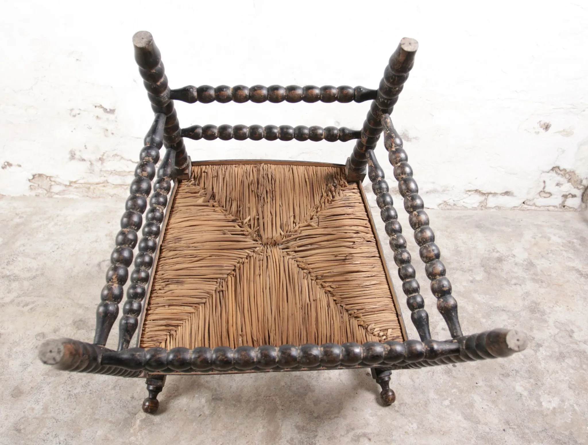 Black bobbin chair with armrests and rush seat – ca. 1900-1930