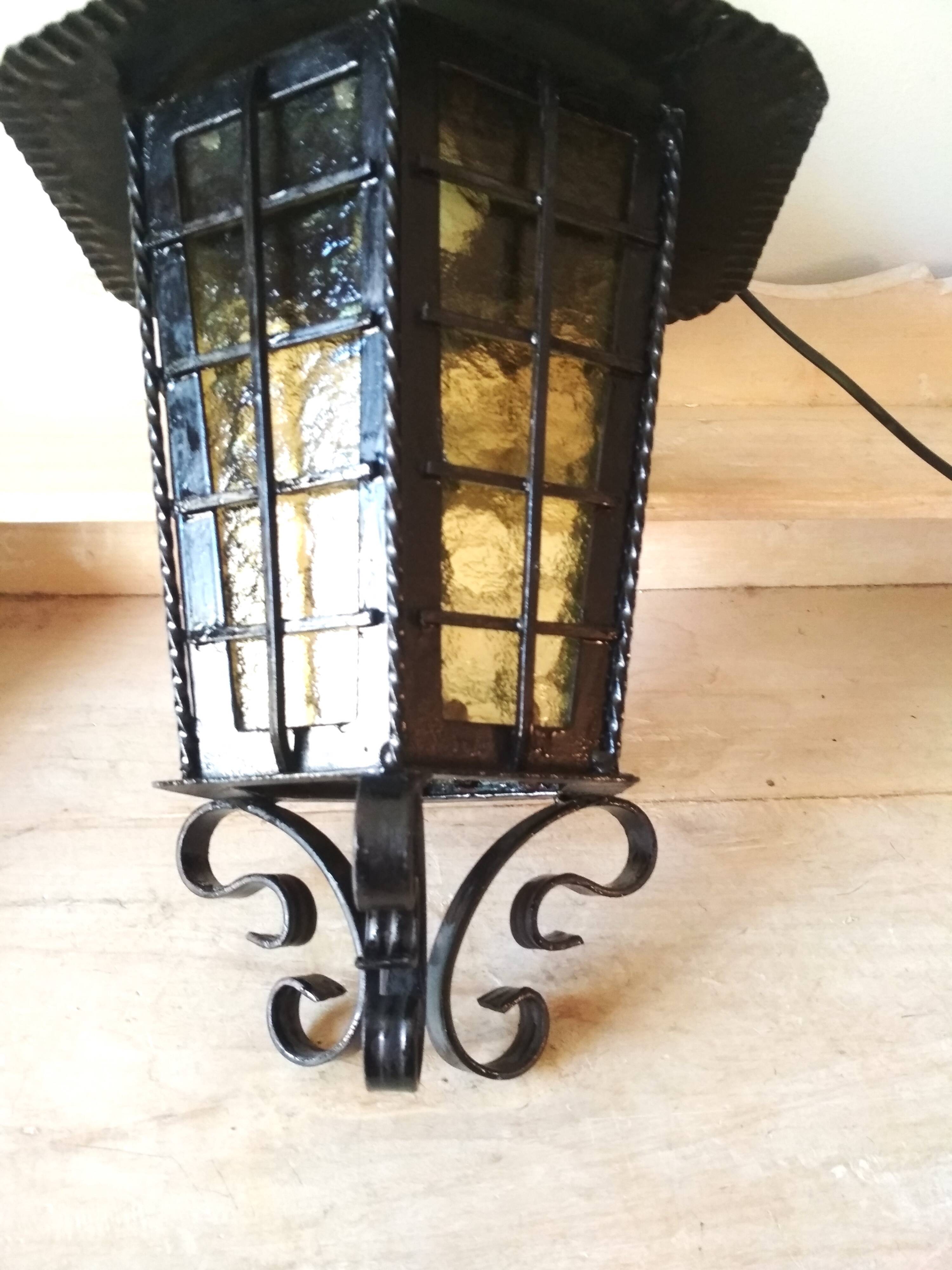 Large hanging lantern in wrought iron and opaque yellow-orange windows