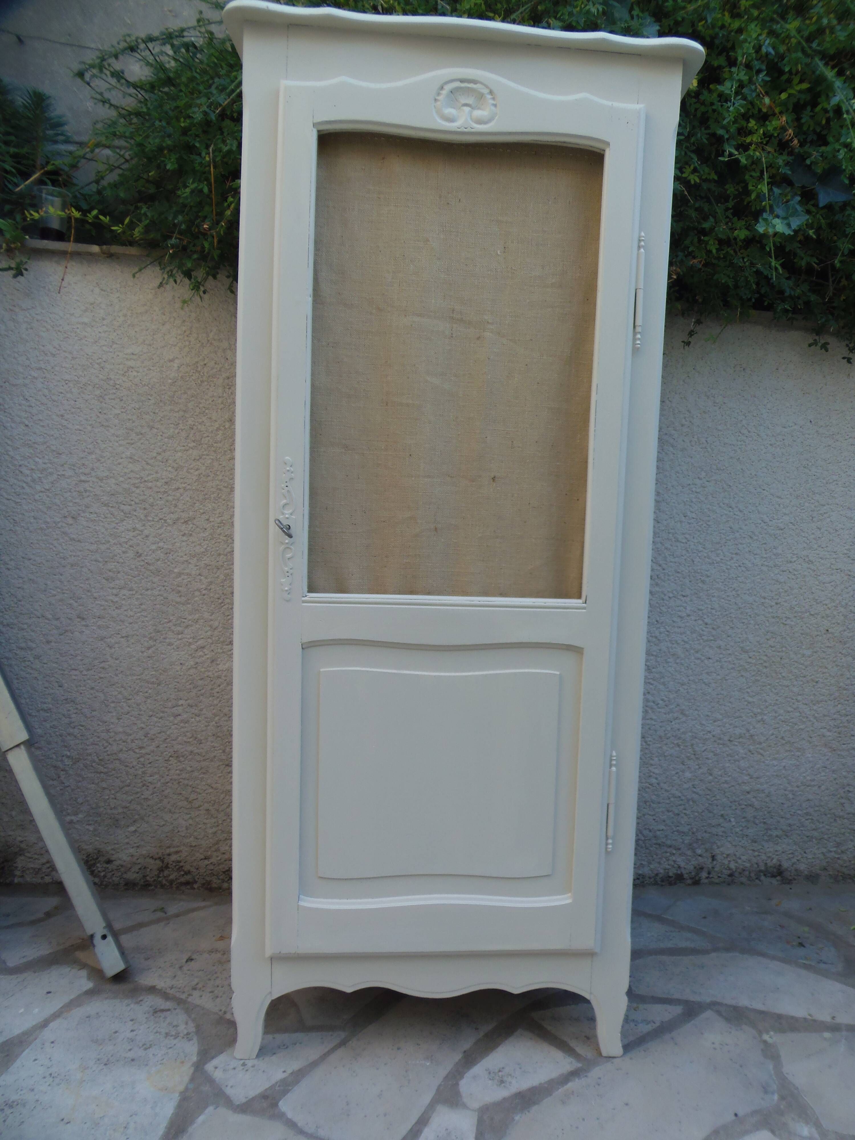 Vintage beige wardrobe made of wood and jute fabric.
