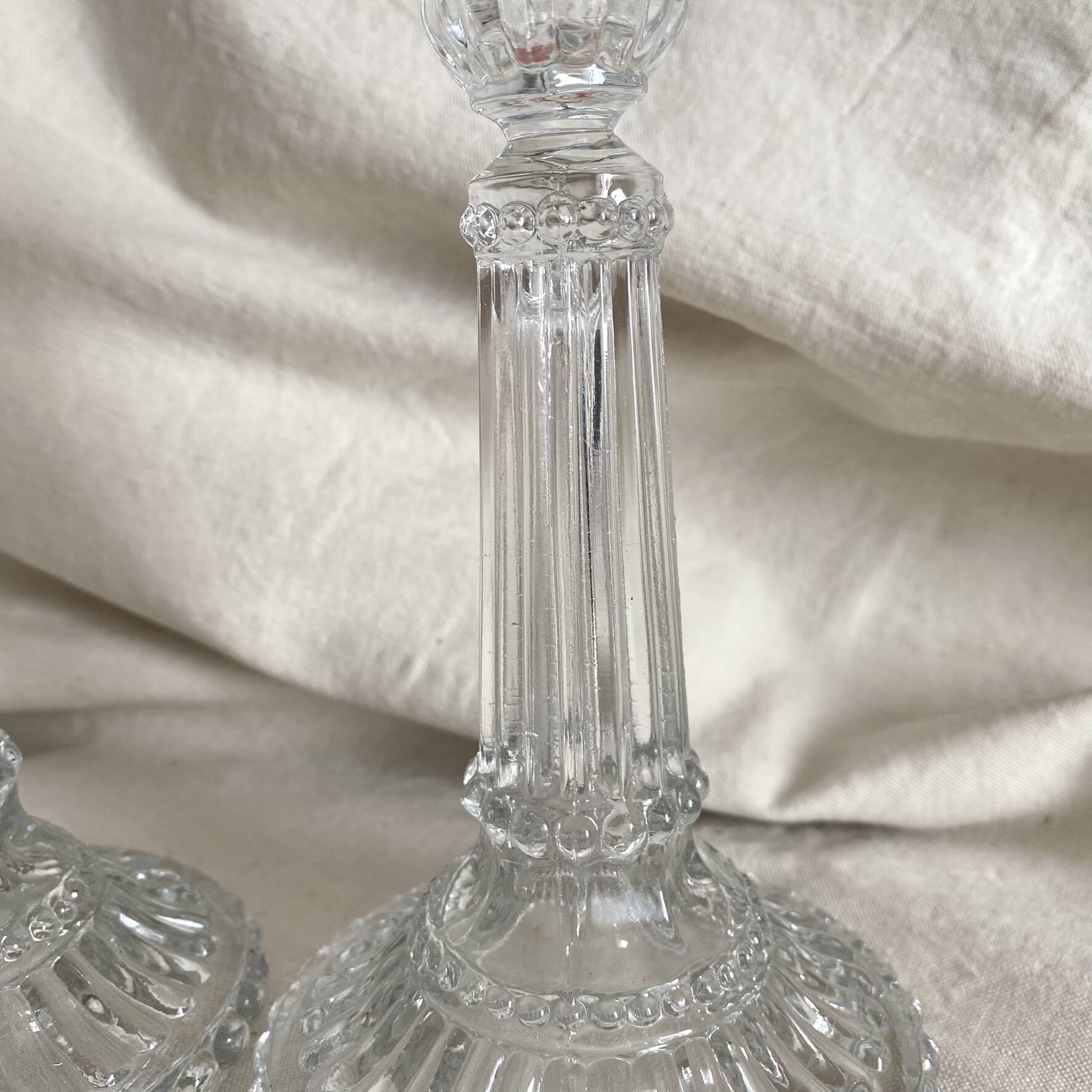Column candle holders in moulded glass made in France.
