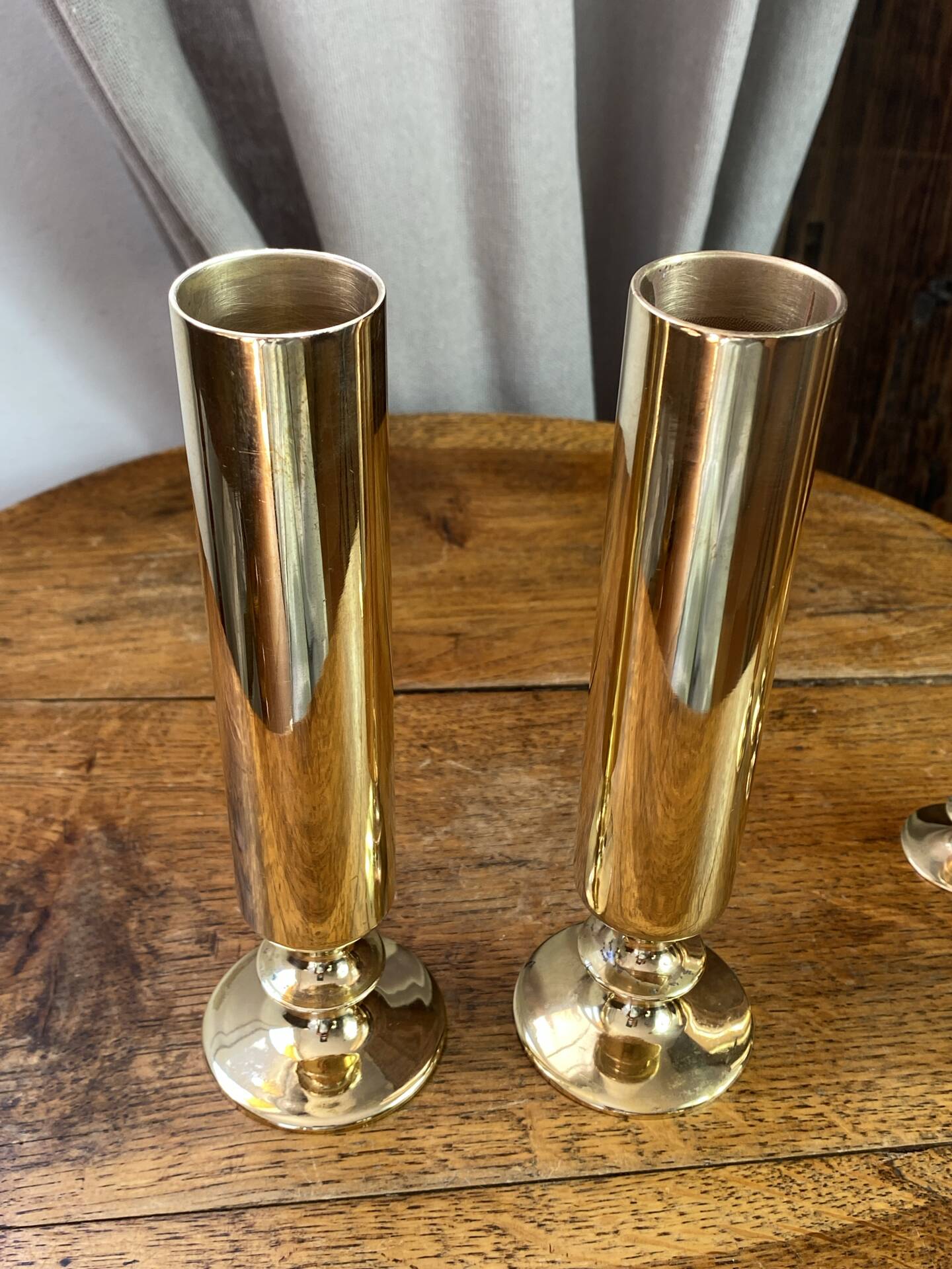 Set of candlesticks and tubular vases in solid brass.