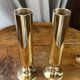 Set of candlesticks and tubular vases in solid brass.