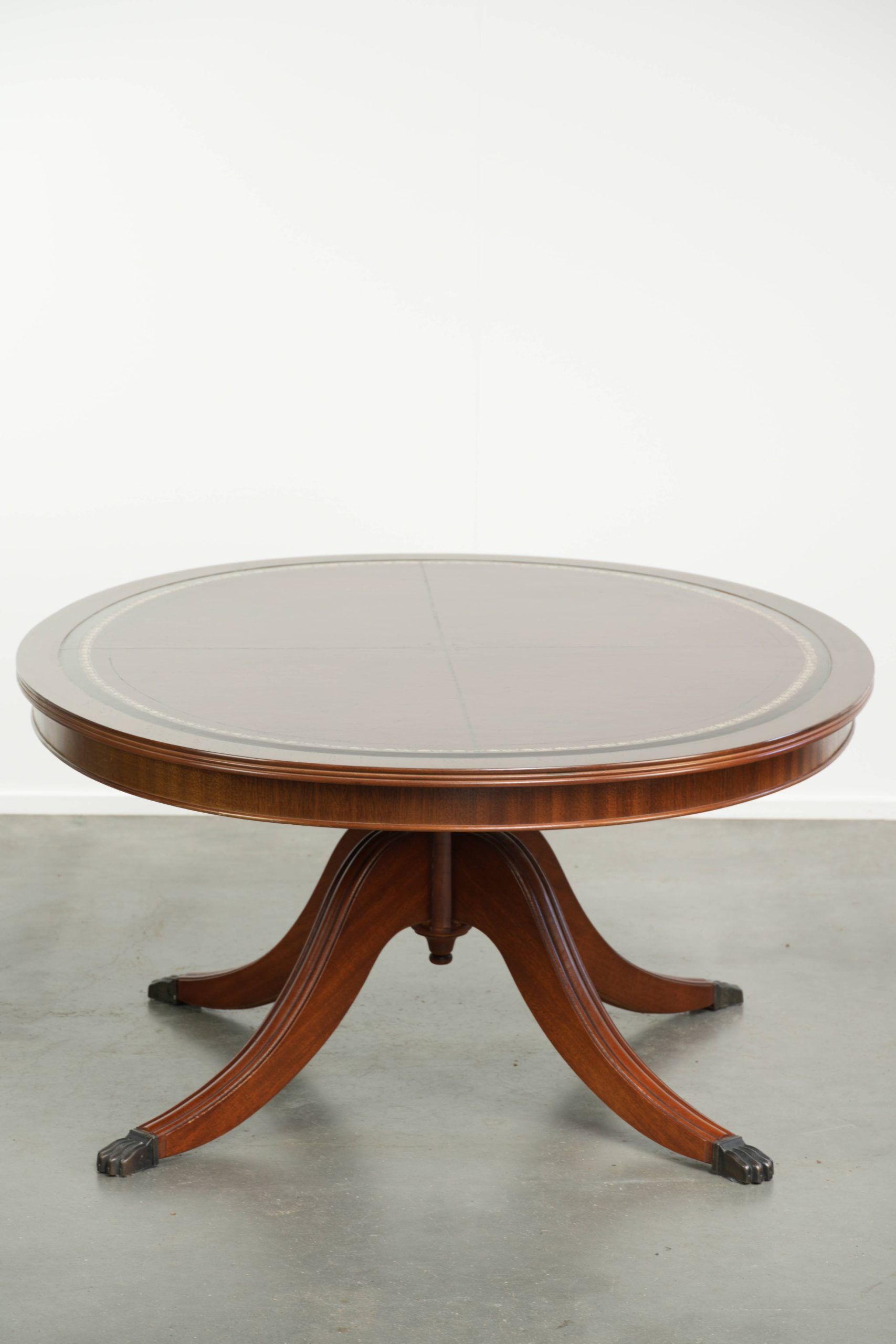 Table basse avec un plateau en cuir rouge de style anglais du 20e siècle.
