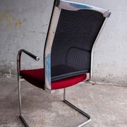 Set of 4 cantilever chairs with burgundy seat and mesh backrest.