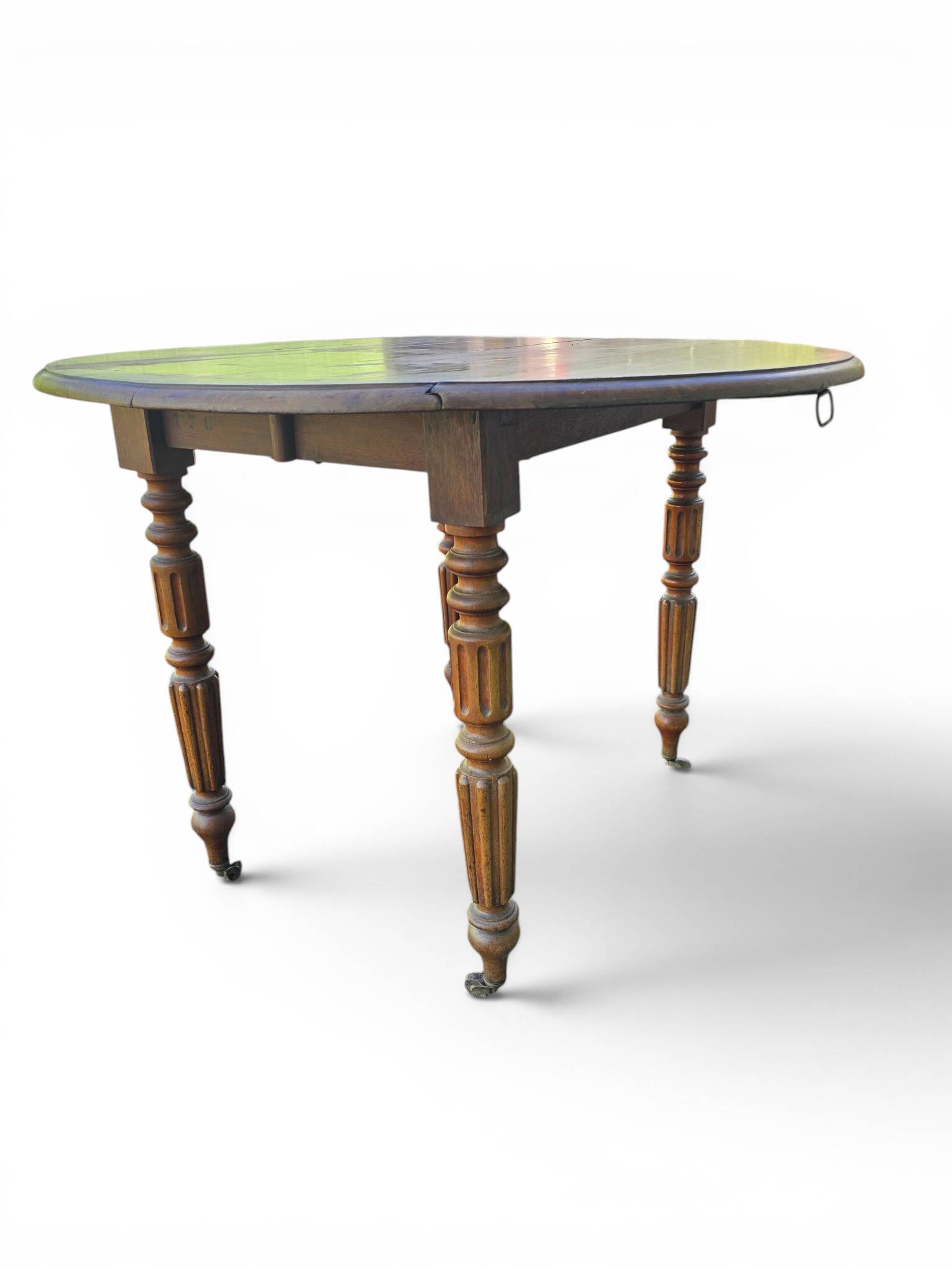 Antique drop-leaf table in wood, with turned legs and castors.