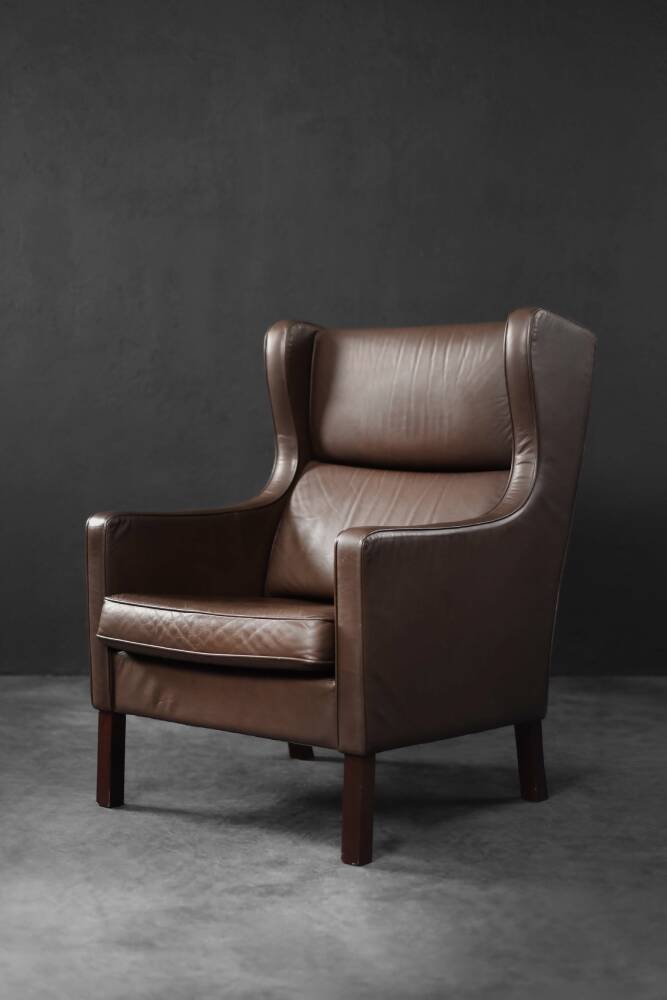 Brown leather wingback chair in mid-century modern Danish style, 1960s.