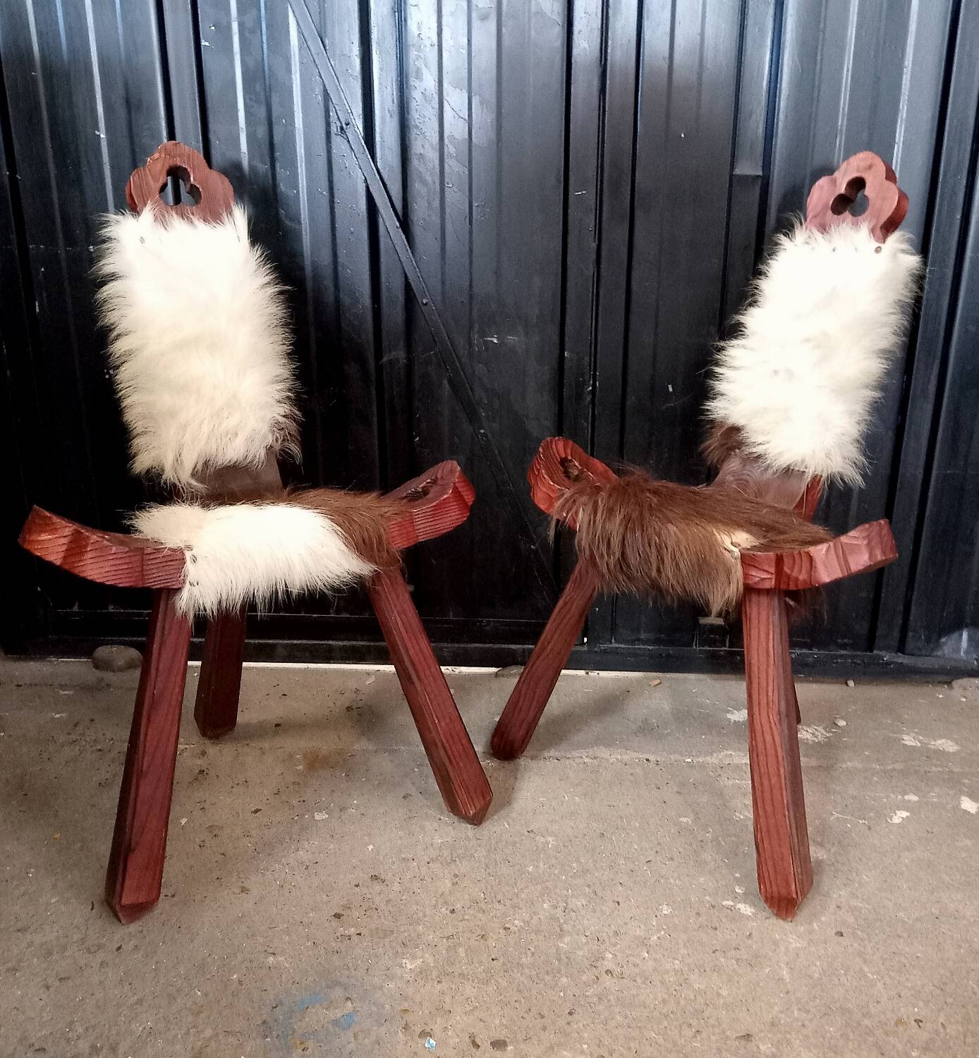 Pair of brutalist tripod chairs in wood and cowhide