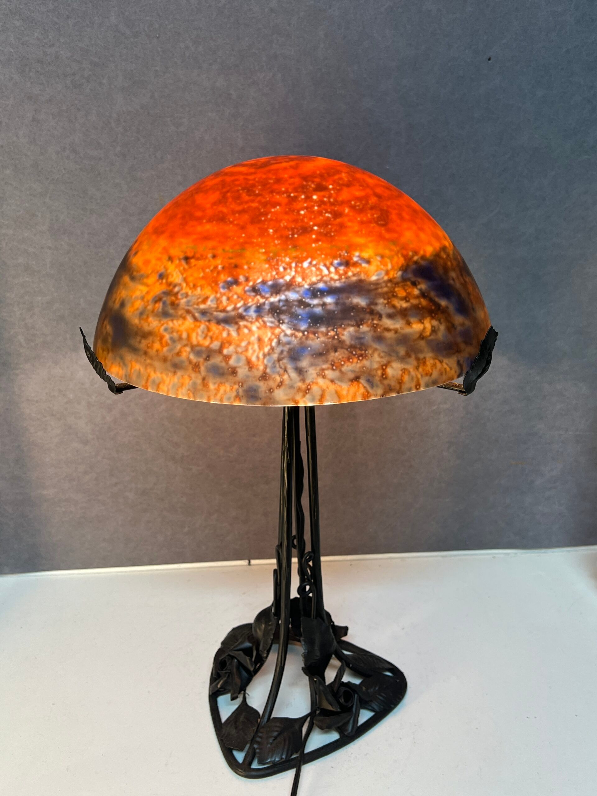 Contemporary mushroom lamp, wrought iron base and shaded orange glass shell