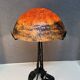 Contemporary mushroom lamp, wrought iron base and shaded orange glass shell