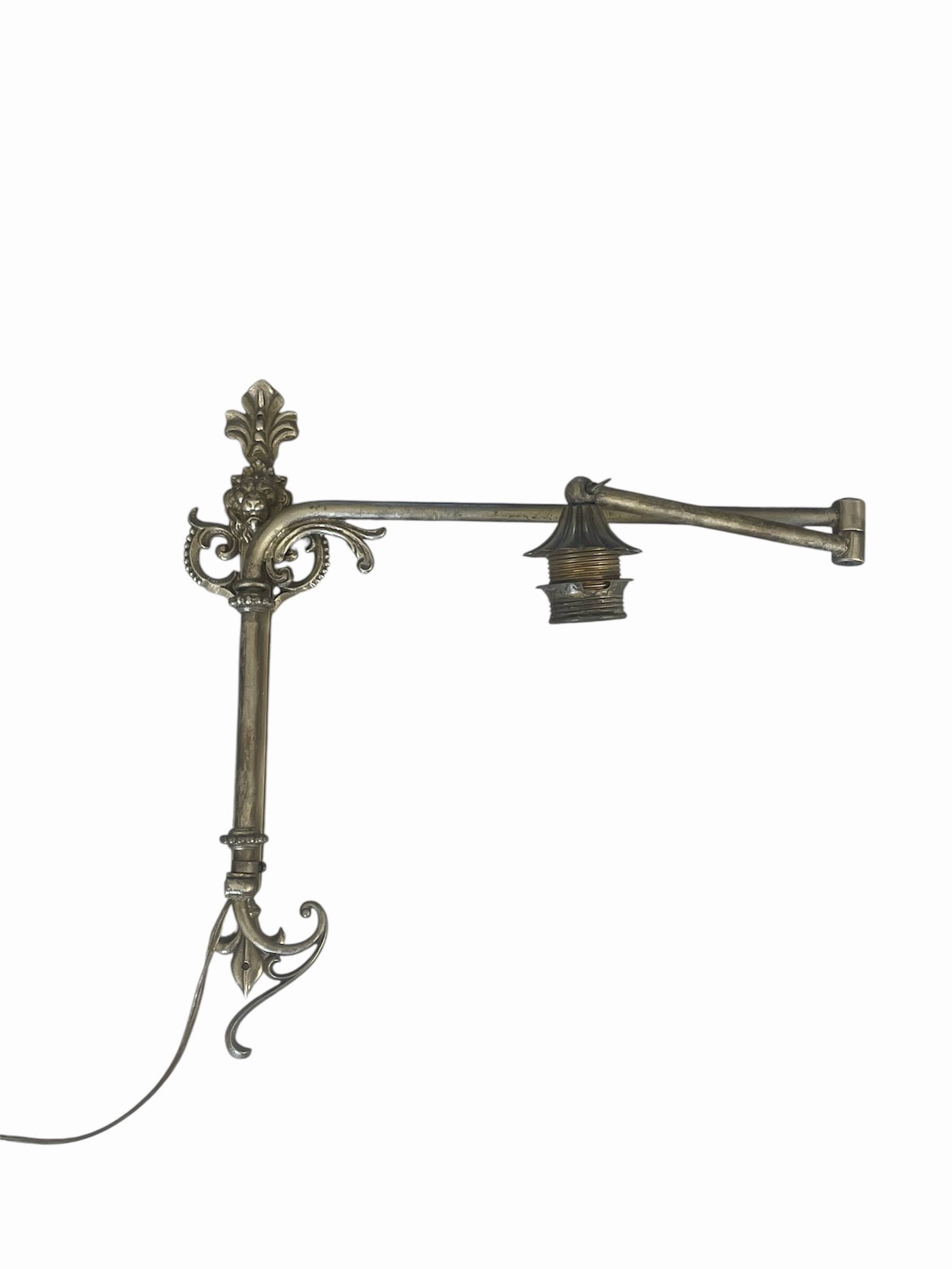 Adjustable wall light in brass and gold metal.