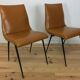 Pair of 1950s chairs with compass legs and brown faux leather.
