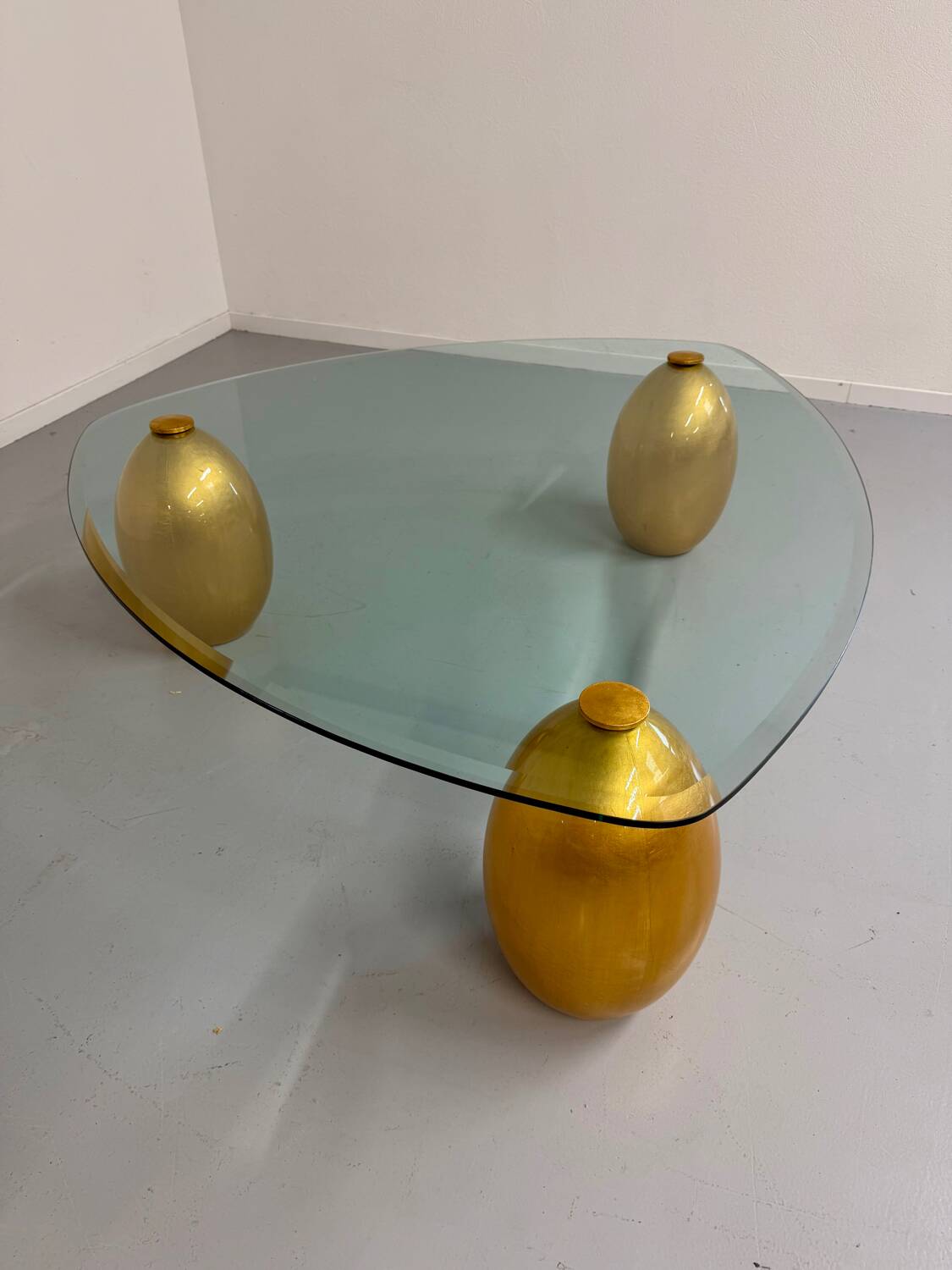 Vintage Italian design coffee table with a glass top and gold base, dating from the 1980s.