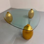 Vintage Italian design coffee table with a glass top and gold base, dating from the 1980s.