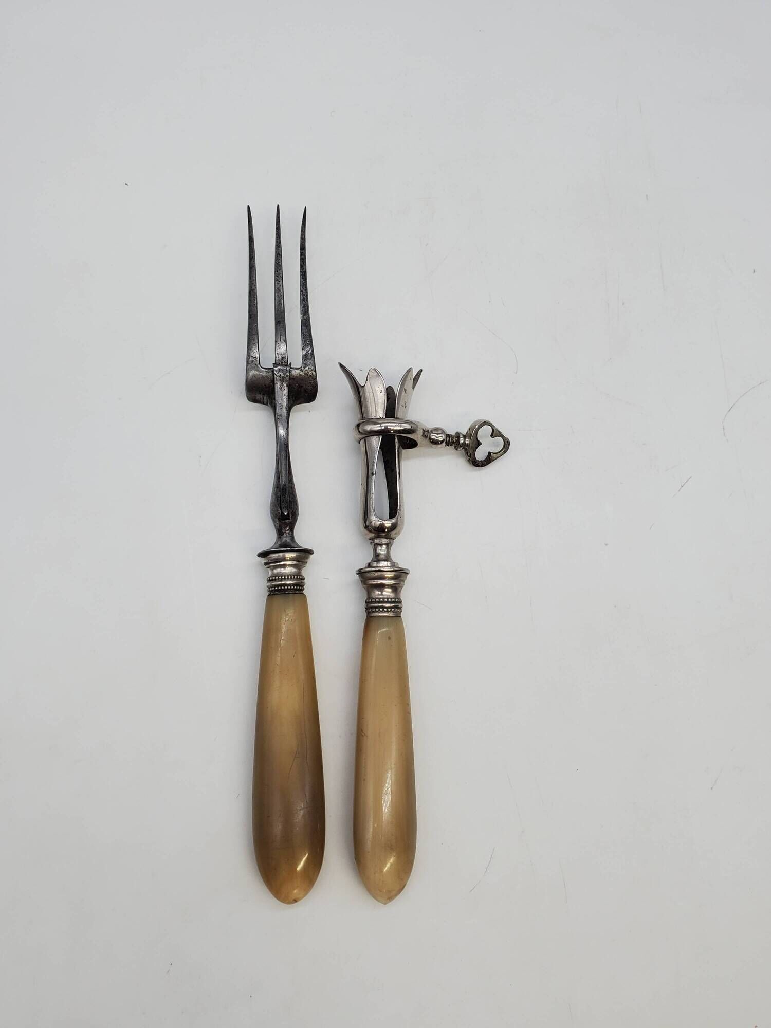 Set of silver-plated leg of lamb handles and fork, with horn handles.