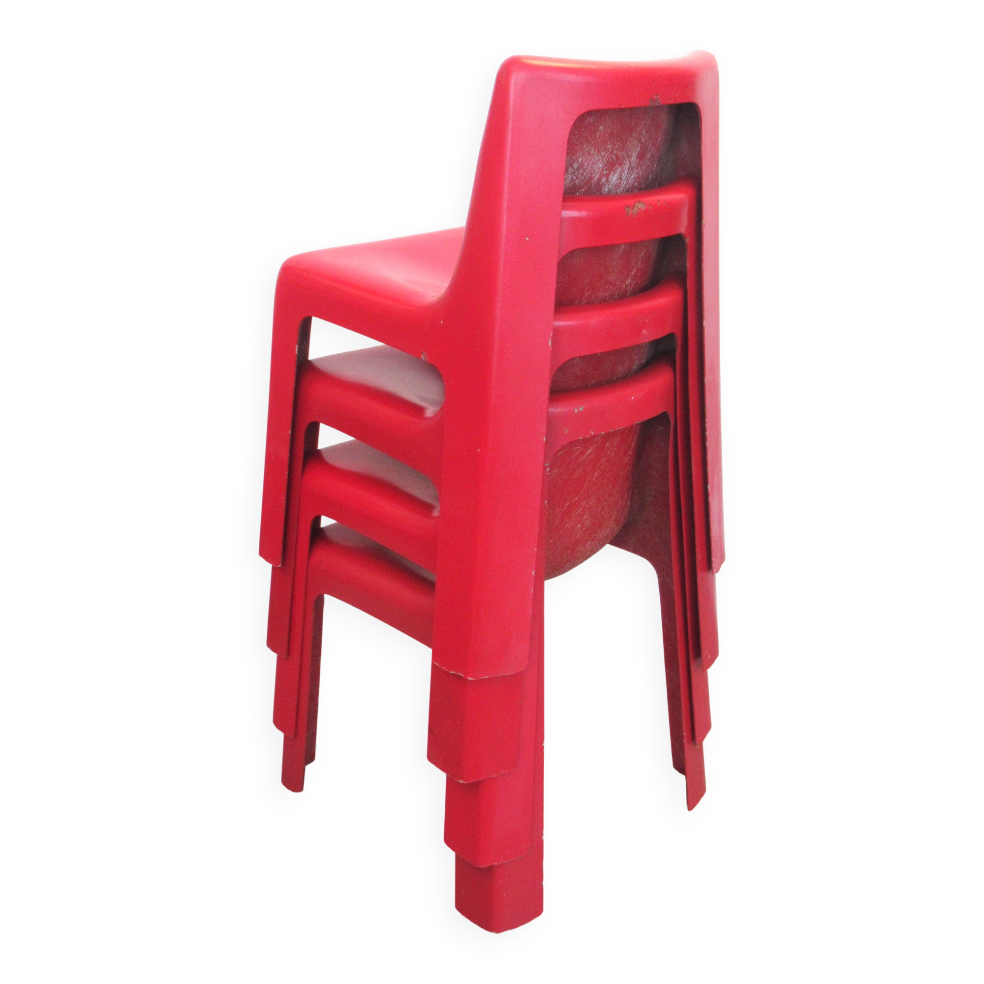 Four red fibreglass chairs from the 1970s.
